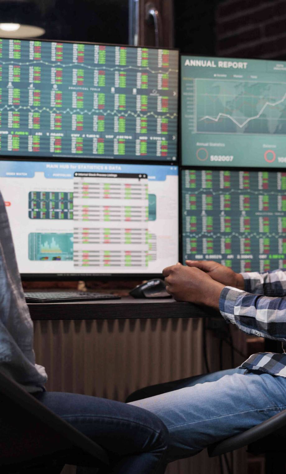 Sales consultants sitting at multi monitor workstation while discussing about stock market positive trend. Investment company coworkers talking about real time financial data analysis report.